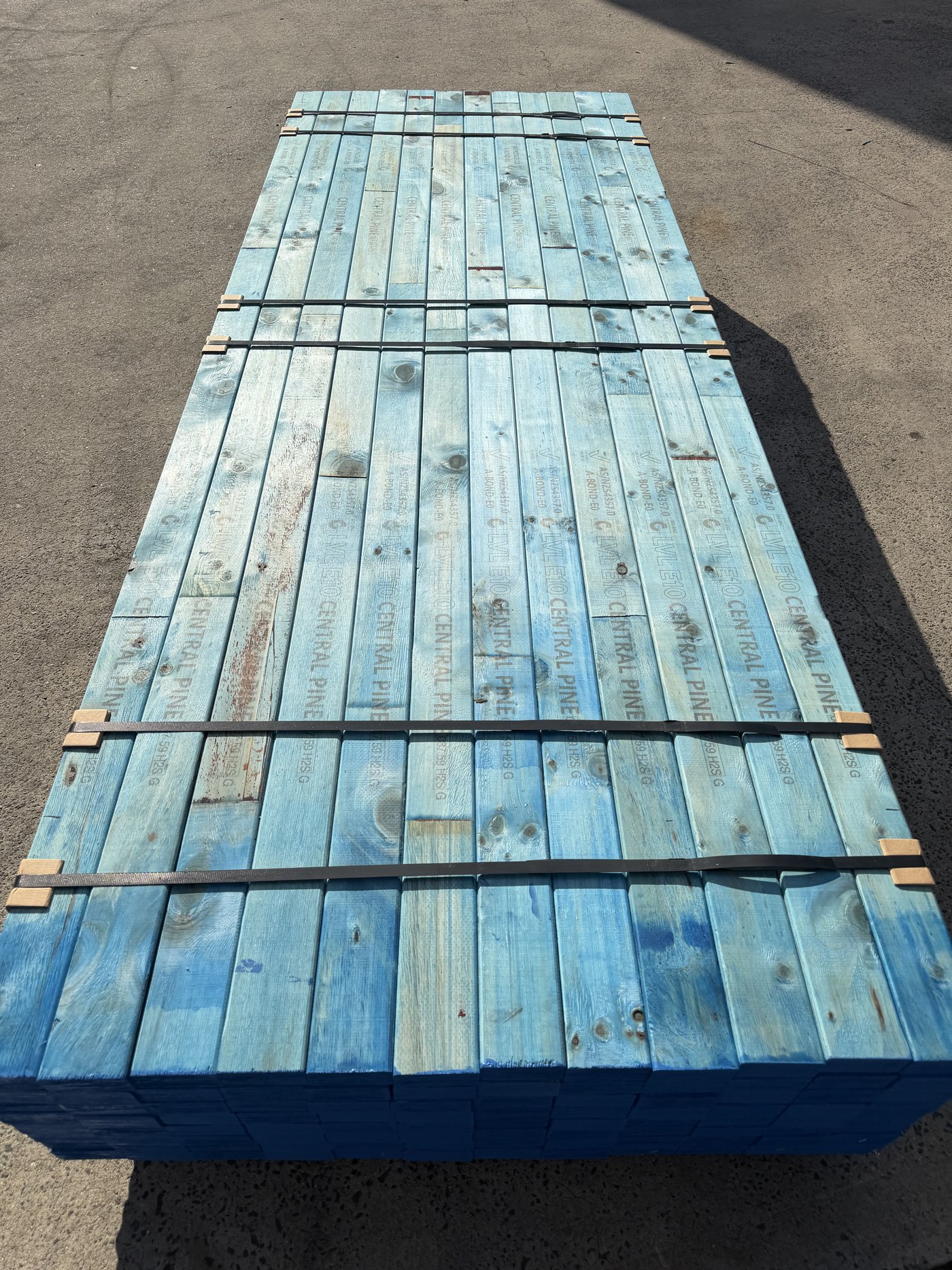 Pack of Central E10 pine 90 × 45 in the yard, blue ends, H2S treated